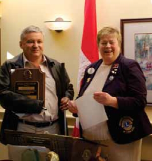 Oriano Belusic (left) receives Lions Clubs International Melvin Jones Fellowship Award from Lions District Governor Georgia Medwedrich. Credit: Don Jones