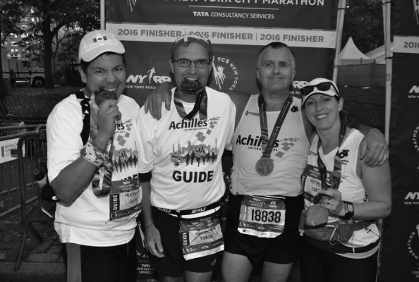 From left to right: Michel Carriere, Laurence Wright, Gaston Bedard and Addie Lee. Team photo after crossing the finish line, taken in front of the NYC Marathon race banner with our medals. Photo Credit - Marc Bedard